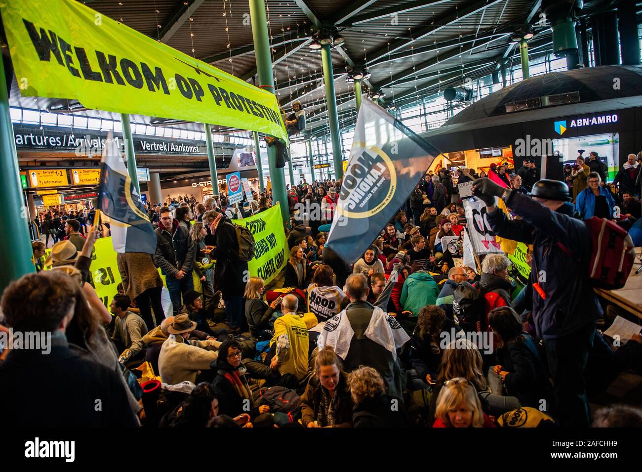 Die Aktivisten sammeln in der Mitte der Flughafen während der Demonstration. Hunderte von Aktivisten friedlich versammelt und Camp rund um den Flughafen für ein Klima plan von Schiphol zu verlangen. Zwei Stufen wurden eingerichtet, einige Vorträge zu halten, die sich im Inneren des Flughafens Schiphol Plaza, wo beschloss die Gemeinde gravierende Einschränkungen auferlegen und keine Proteste zu erlauben es, wo die Passagiere ständig vorbei war. Mehrere Verhaftungen in der Mitte der Flughafen, wenn die Aktivisten weigerte, den Platz zu verlassen. Stockfoto