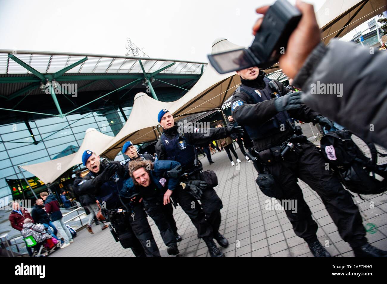 Ein Aktivist wird von der militärischen Polizei während der Demonstration festgenommen. Hunderte von Aktivisten friedlich versammelt und Camp rund um den Flughafen für ein Klima plan von Schiphol zu verlangen. Zwei Stufen wurden eingerichtet, einige Vorträge zu halten, die sich im Inneren des Flughafens Schiphol Plaza, wo beschloss die Gemeinde gravierende Einschränkungen auferlegen und keine Proteste zu erlauben es, wo die Passagiere ständig vorbei war. Mehrere Verhaftungen in der Mitte der Flughafen, wenn die Aktivisten weigerte, den Platz zu verlassen. Stockfoto