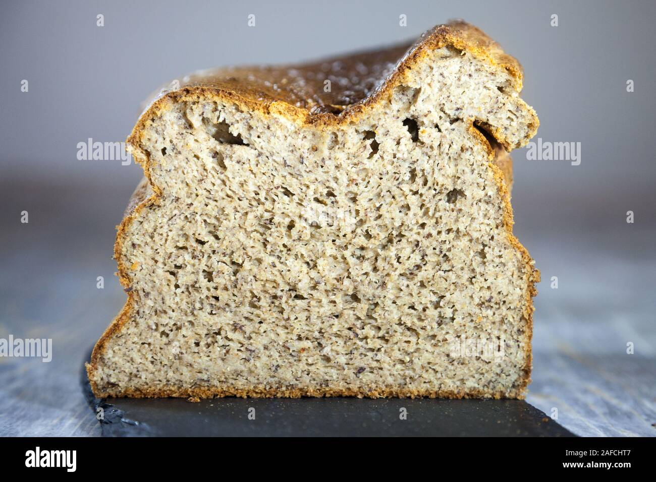 Laib eines französischen Glutenfrei Last von Brot, geschnitten und in Scheiben geschnitten, aus dem Profil gesehen. Es wird als eine Alternative für Menschen mit gesundheitlichen Problem entwickelt, BWS Stockfoto