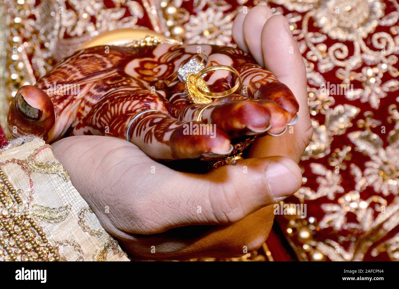 Eine indische Braut und Bräutigam hielten ihre Hände mit Ring während einer hinduistischen Hochzeit Ritual Stockfoto