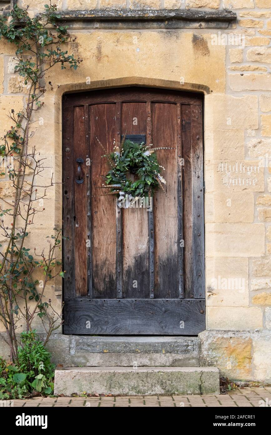 Weihnachten Kranz auf eine alte Eiche Haustür in Chipping Campden. Cotswolds, Gloucestershire, England Stockfoto