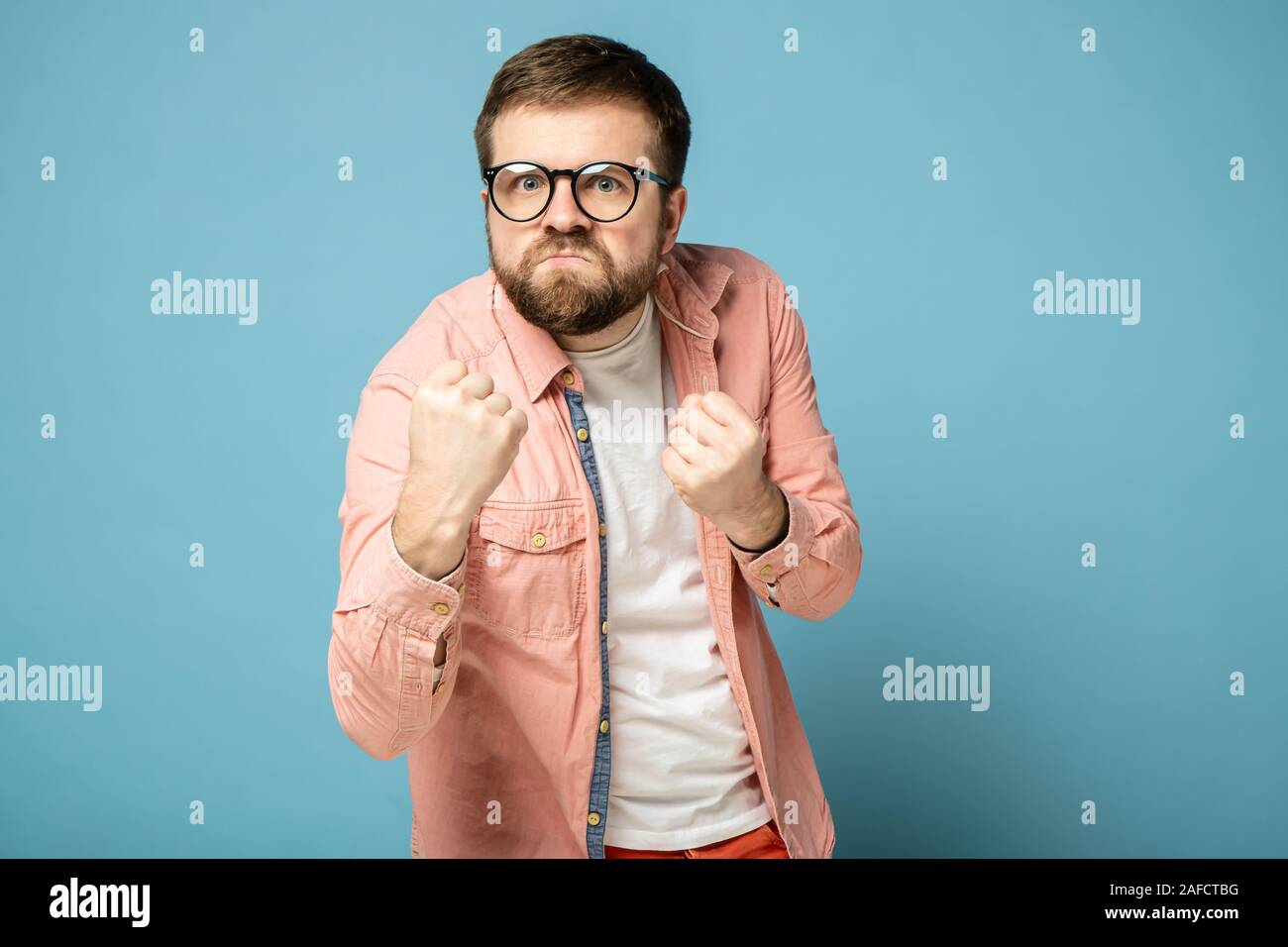 Bärtiger Mann mit Brille ballte seine Fäuste und wollte sich selbst zu  verteidigen, mit einem lustigen Ausdruck auf seinem Gesicht Stockfotografie  - Alamy