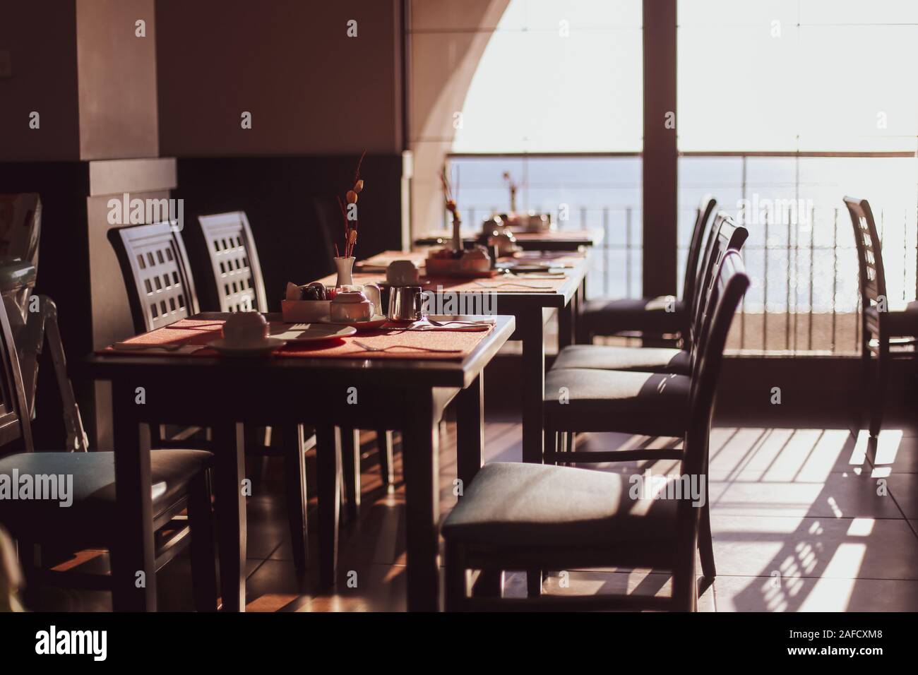 Flache Tiefenschärfe (selektive Fokus) Bild mit Tabellen in einem Restaurant beim Frühstück am frühen Morgen Stockfoto