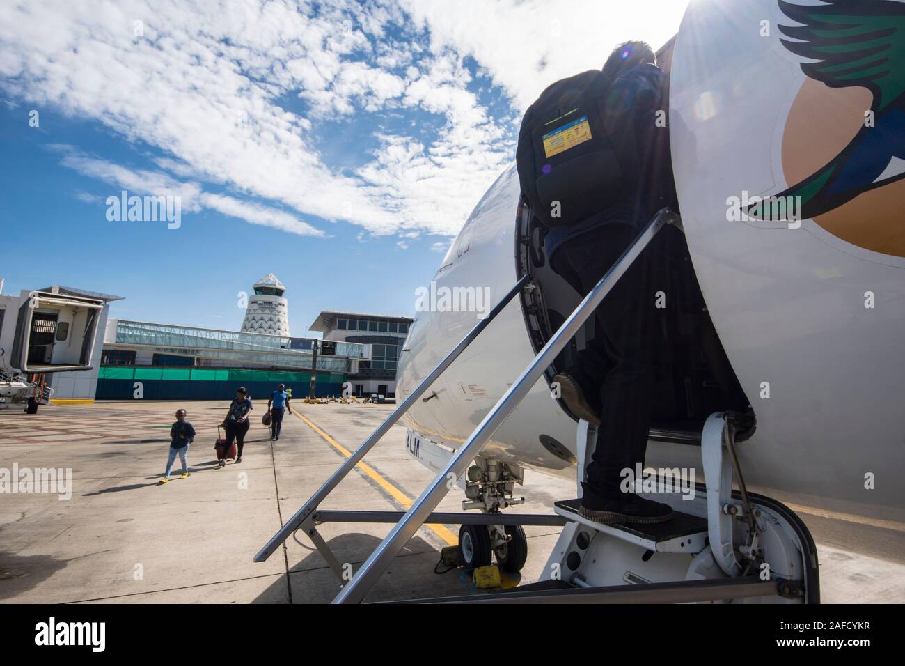 Harare, Simbabwe. Passagiere besteigen ein Fastjet Embraer-145-Flugzeug auf dem Flughafen Robert Gabriel Mugabe. Kontrollturm im Hintergrund. Stockfoto