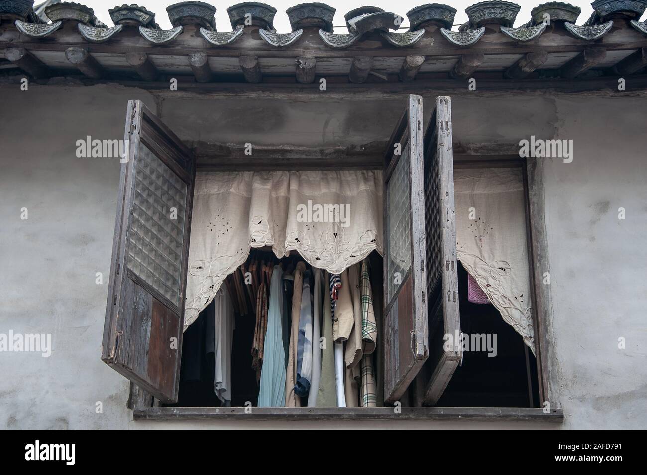 Wäsche hängt, in ein offenes Fenster, das Trocknen in der Sonne. Street Scene, Wuxi, China. Stockfoto