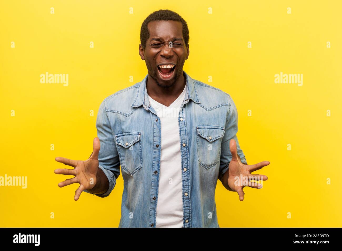 Portrait von wütenden irritiert betonte Mann in Jeans casual Shirt suchen Mad mit erhobenen Händen und schrie mit Zorn, aggressiv und verrückt. ind Stockfoto