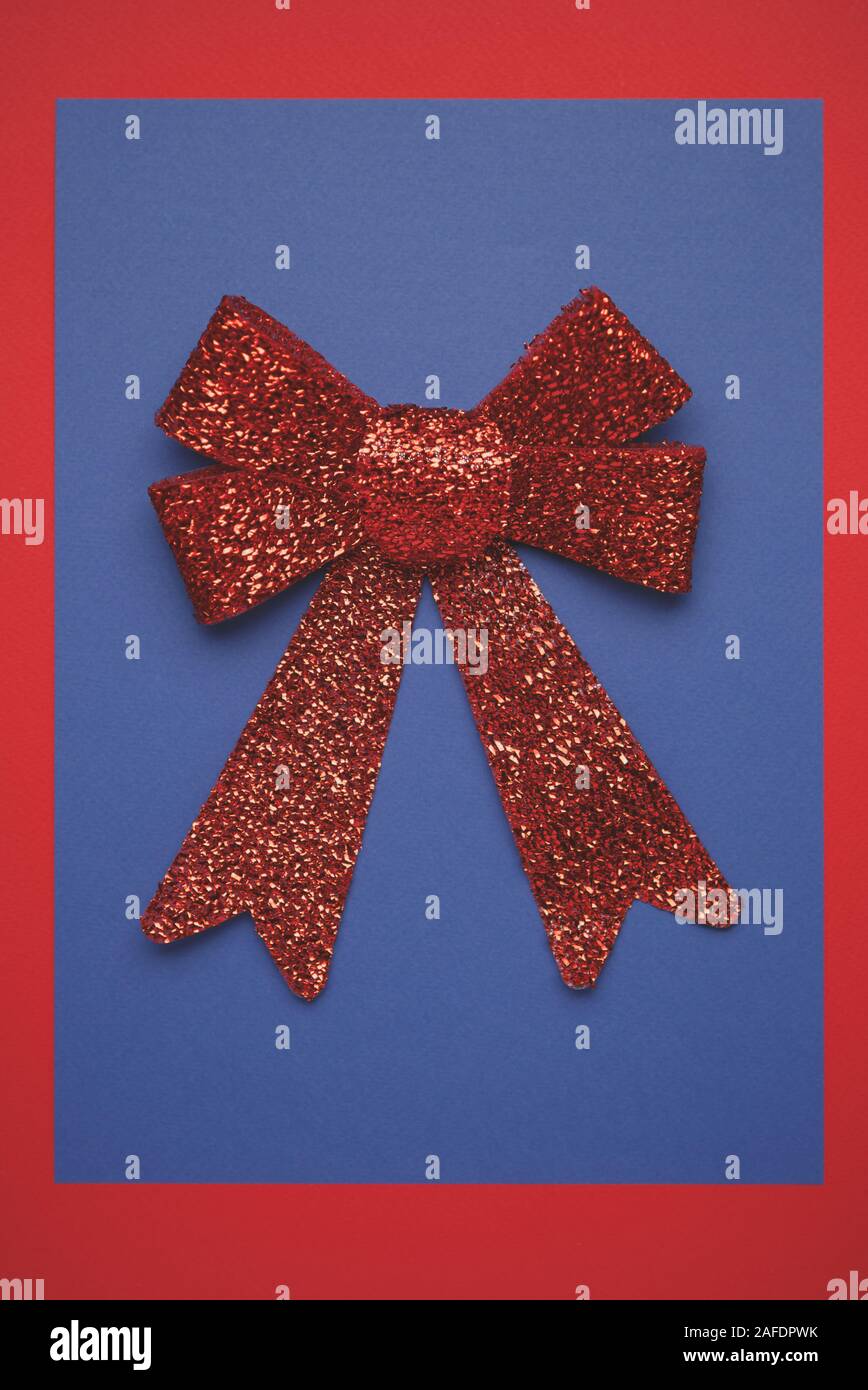Red Ribbon auf blauem Papier Hintergrund. Red Christmas Kulisse mit festlichen Dekorationen. Winter Urlaub Einrichtung von oben im flachen Layout Stil geschossen. Postcar Stockfoto