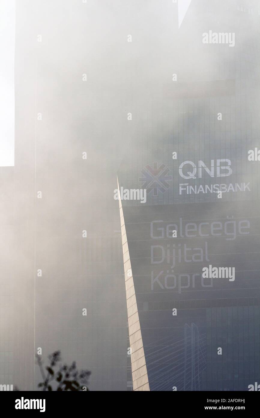 In der Nähe von QNB Finansbank Hauptquartier bei Levent, Istanbul, in einer nebligen Morgen mit Logo, Text, Name und ein bisschen Werbung auf der Außenseite. Stockfoto