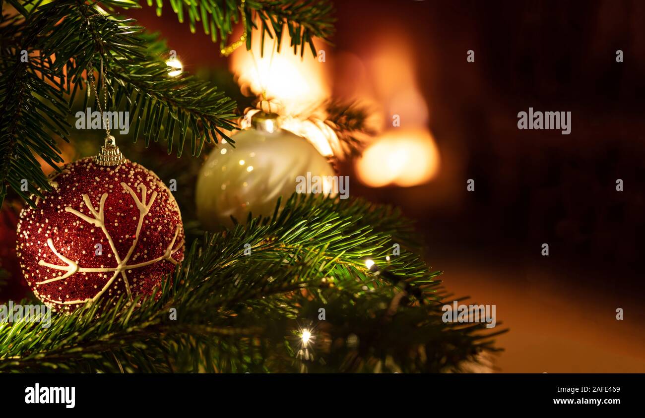 Christmas Ball closeup, Blur glühenden Kamin Hintergrund. Xmas tree ornament, kopieren. Warme und gemütliche Ferienhaus Stockfoto