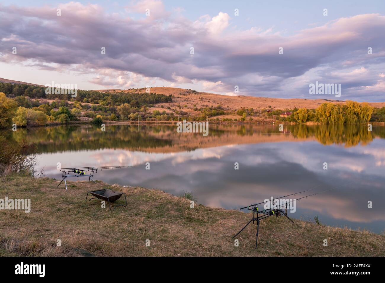 Karpfen angeln karpfen beißen Indikatoren und Rollen auf rod pod in der Nähe des Flusses. Angeln bei Sonnenaufgang. Stockfoto