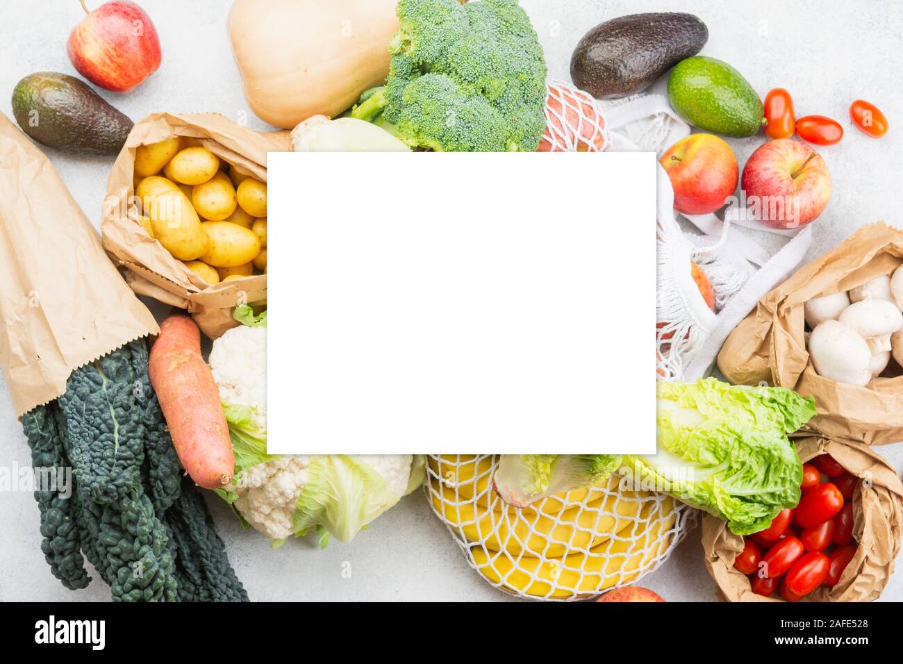Sortiment an Gemüse Obst in wiederverwendbaren Weiß Mesh, Baumwolle und Papiertüten auf weißen Küche Tabelle, Ansicht von oben, selektive konzentrieren. White Paper Auf, kopieren Sie Platz für Text Stockfoto