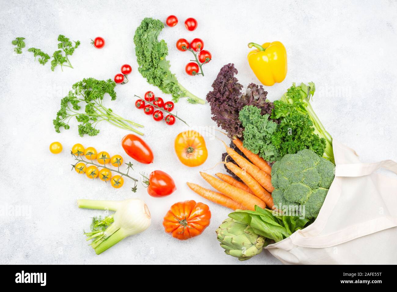 Null Abfall heatlhy Shopping Konzept. Gemüse fliegen aus der wiederverwendbaren Baumwolltasche über die weiße Küche oben, Ansicht von oben, selektiver Fokus Stockfoto