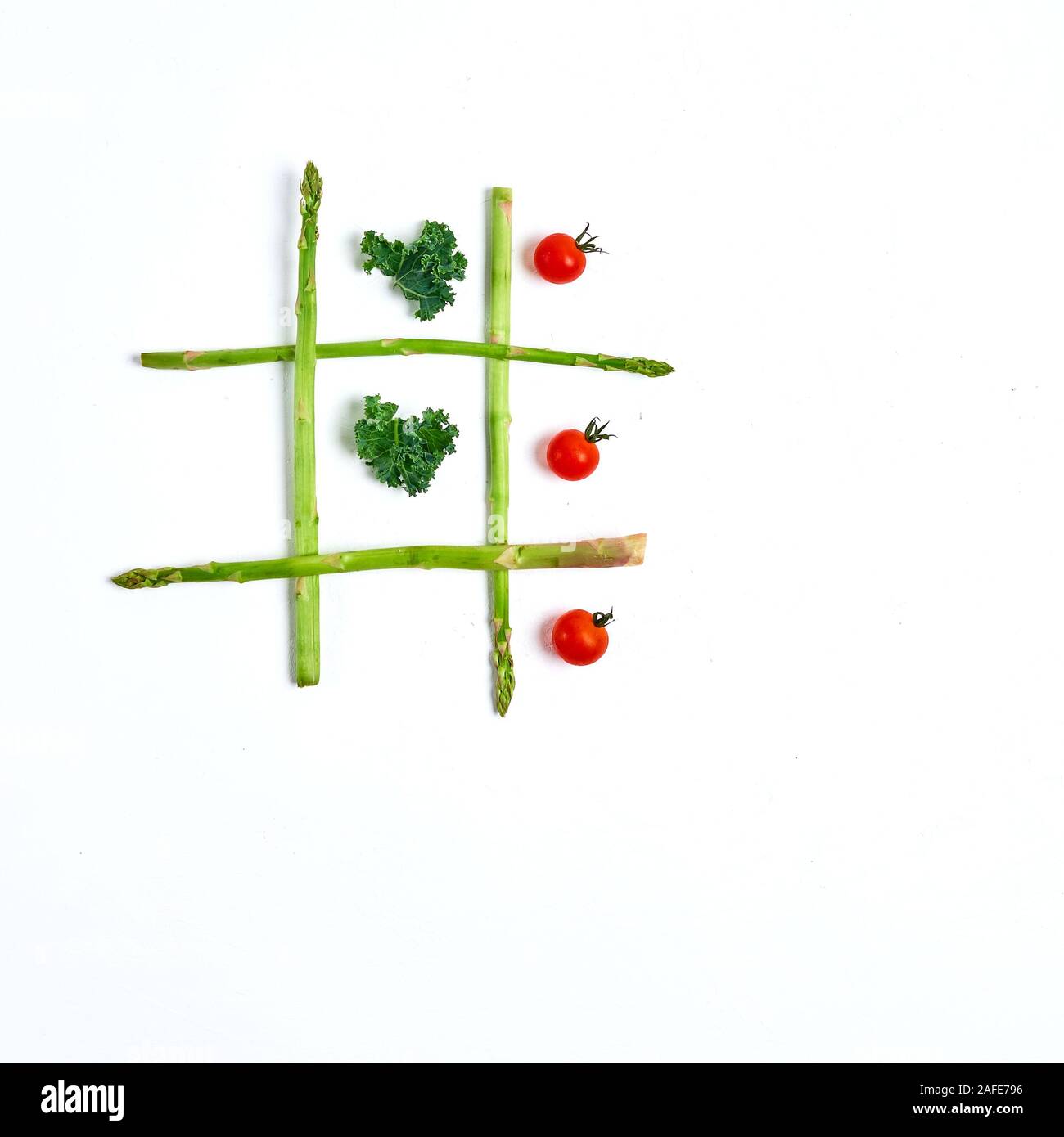 Tic Tac Toe mit Essen, Spargel Grünkohl, Tomaten, Ansicht von oben Stockfoto