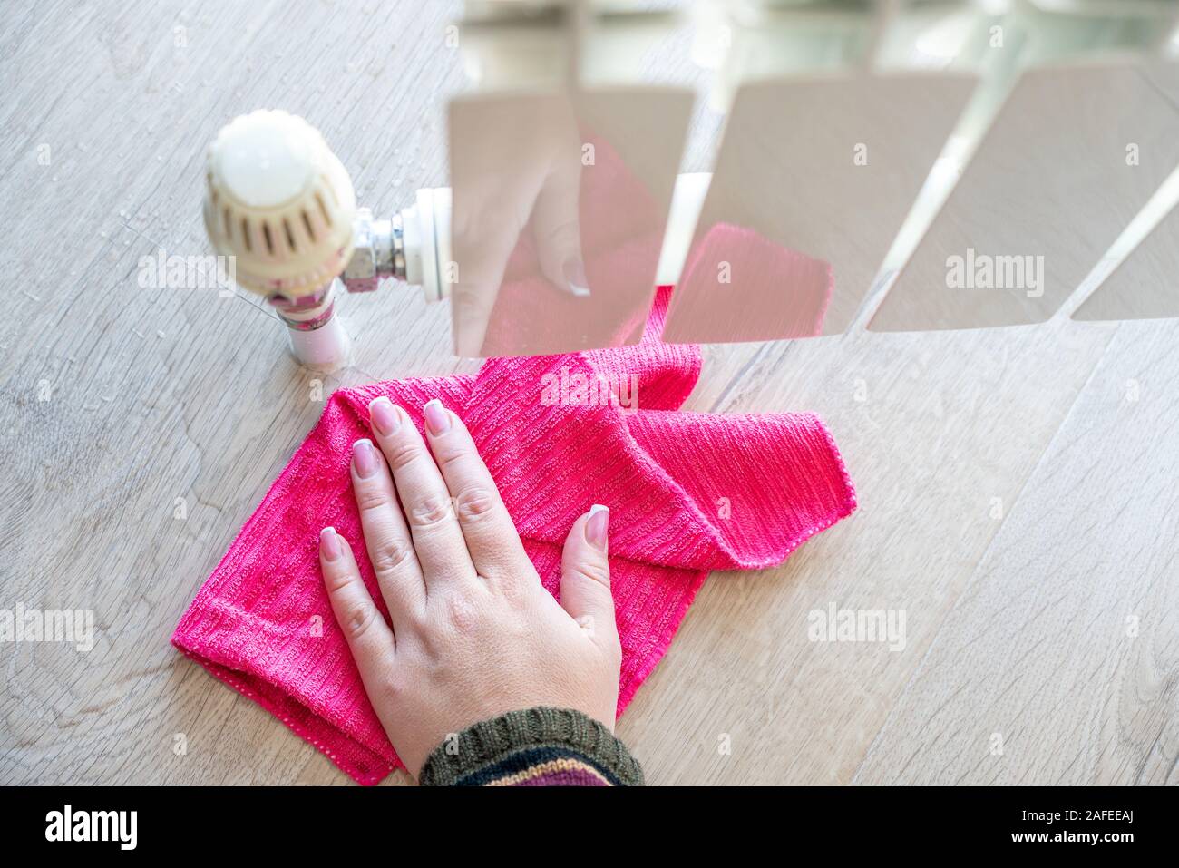 Weibliche hand mit Lappen reinigen Wasser von der Heizung Kühler  Stockfotografie - Alamy