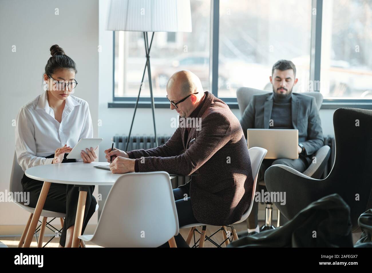 Gruppe von interkulturellen beschäftigt Mitarbeiter in formale Arbeiten im Hotel Lounge Stockfoto