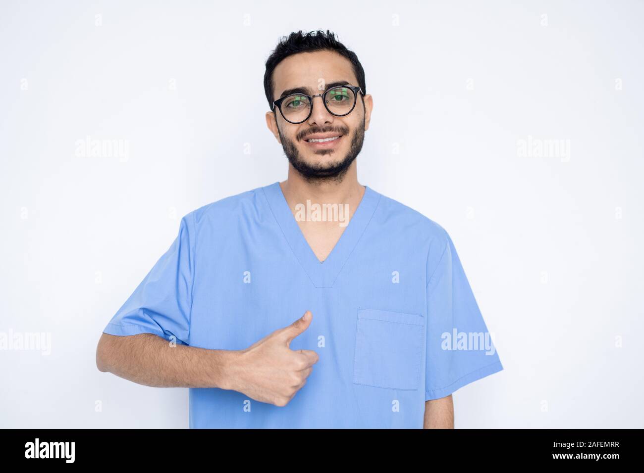 Junge erfolgreiche männlichen Chirurgen oder Arzt in der blauen Uniform mit Daumen hoch Stockfoto