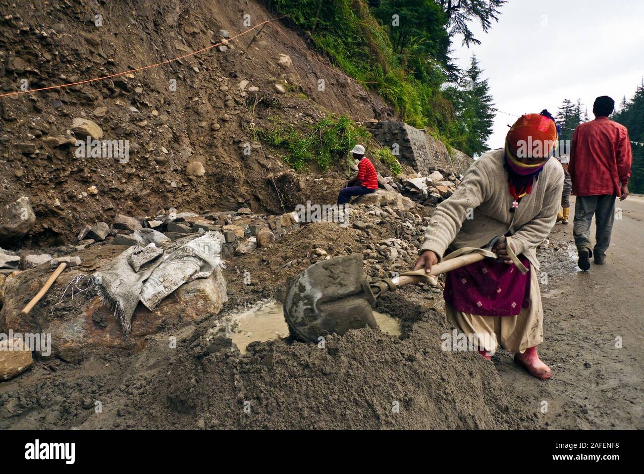 Vashisht, Himachal Pradesh, Indien: eine indische Frau bereitet Zement eine Straße zum Renovieren Stockfoto