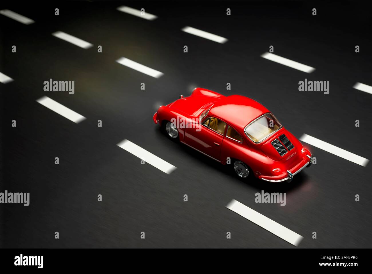 Izmir, Türkei - 28. Juli 2019. Ober- und Rückseite des Porsche Carrera 2 Spielzeug Modell Auto auf einer asphaltierten Straße Hintergrund mit Bewegungsunschärfe. Stockfoto