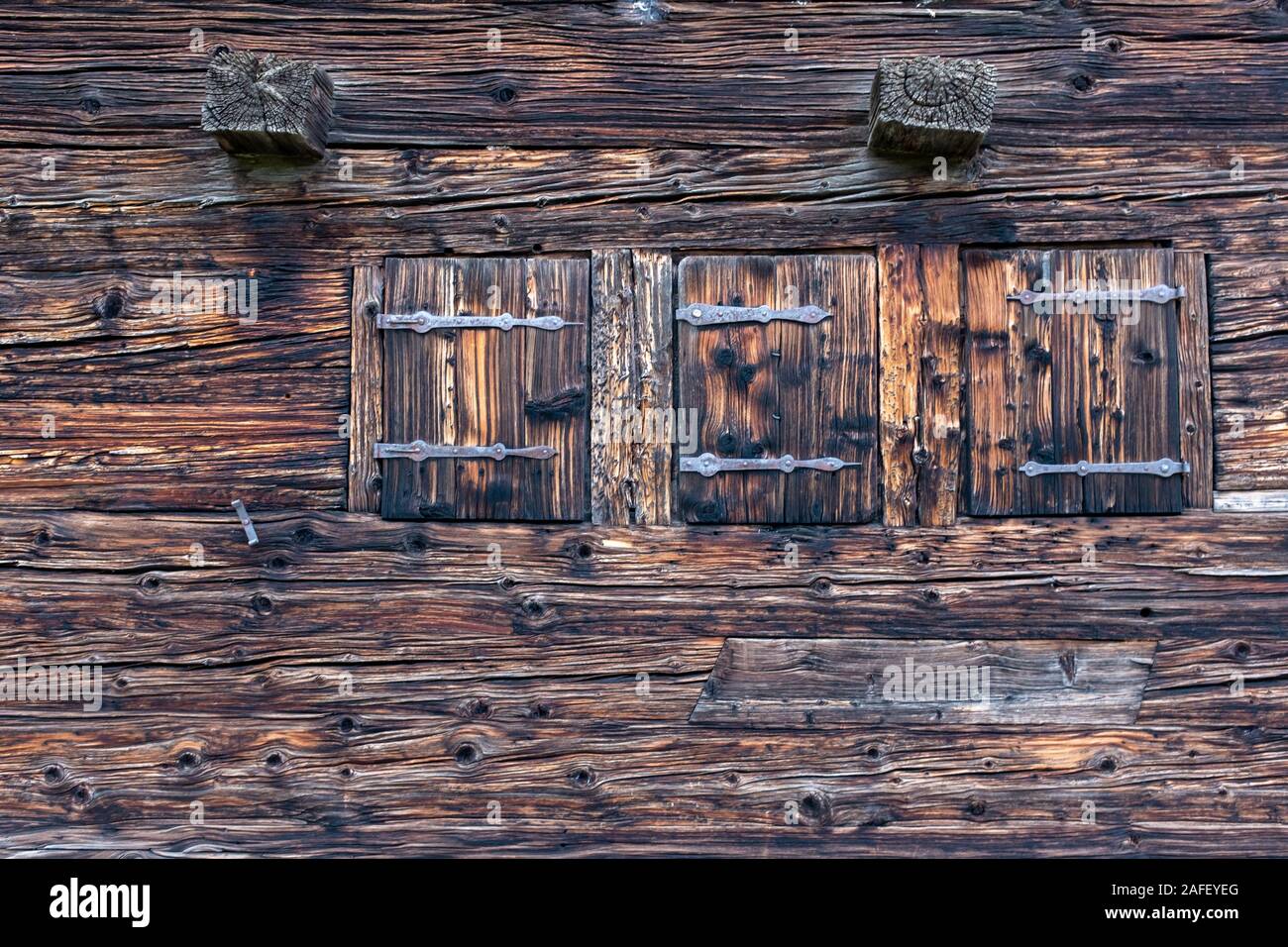 Drei geschlossenen Fenstern mit Fensterläden auf einem alten Schweizer Bauernhof Stockfoto