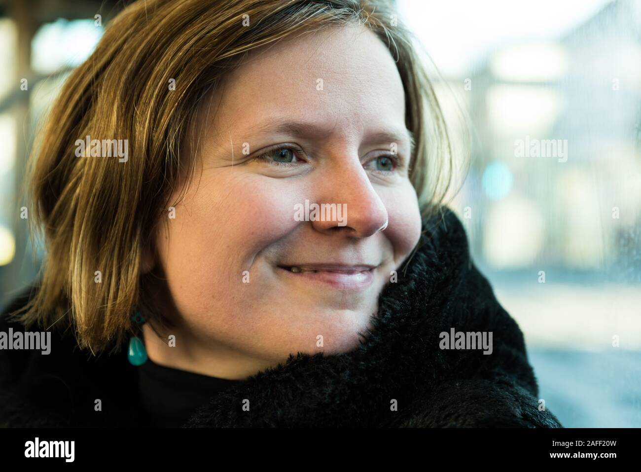 Dreißigjährige attraktive Frau posiert in der Straßenbahn Stockfoto