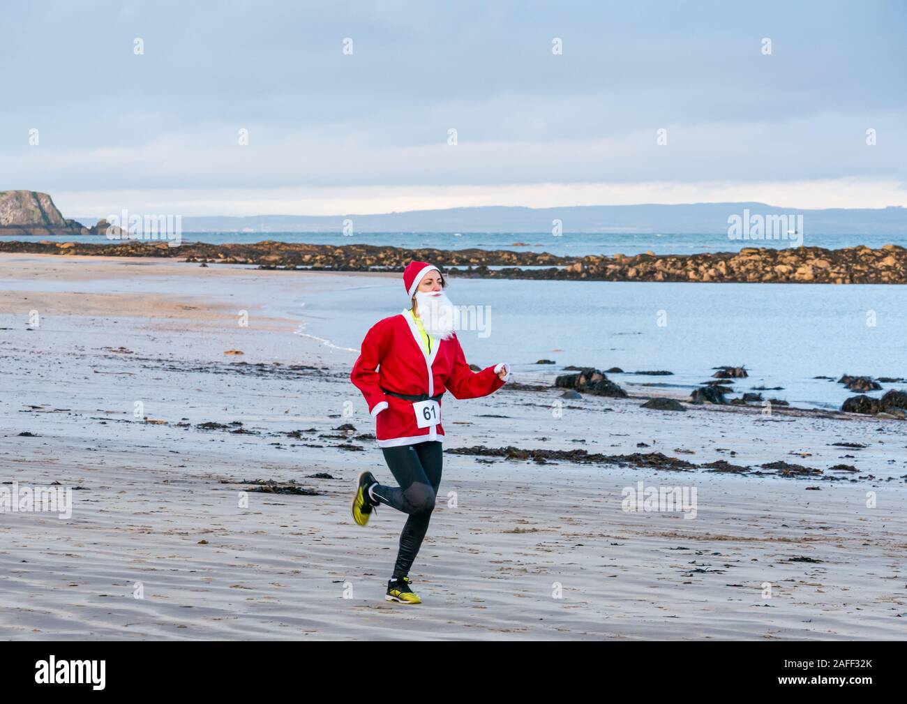 Frau in Santa run auf Beach, North Berwick, East Lothian, Schottland, Großbritannien Stockfoto