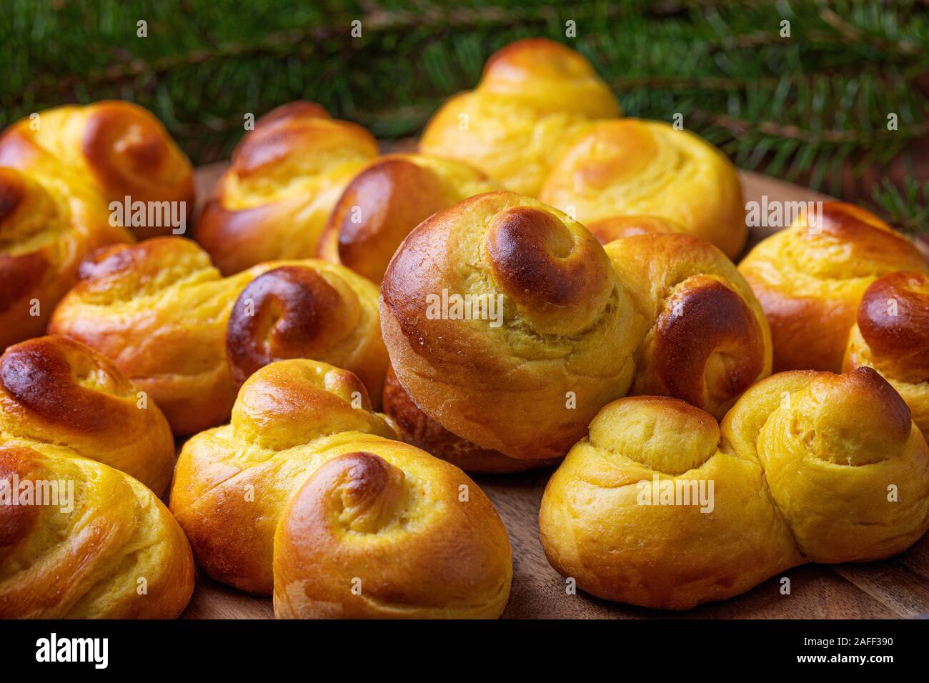 Schwedische traditionelle Weihnachten bun Lussekatter oder Lussebullar auf Holz- fach die Brötchen sind frisch und hausgemacht, und es gibt eine Defokussierten br Fichte Stockfoto