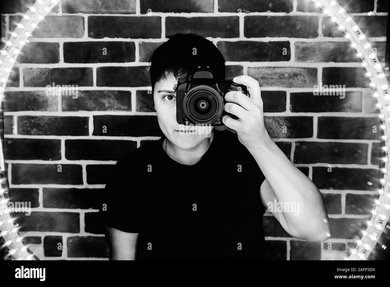 club Fotograf nimmt Selfie in Spiegelreflexion monochrome LED-Lichter Stockfoto
