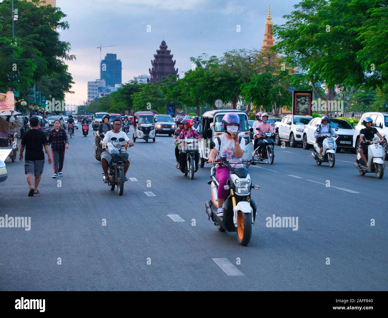 Abends Verkehr auf Preah Sihanouk Boulevard in der Nähe der Norodom Sihanouk Denkmal, das im Hintergrund angezeigt wird. Stockfoto