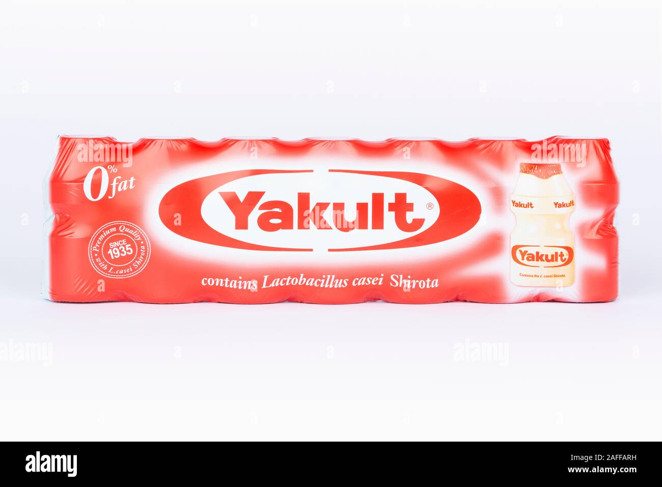 Eine 7er Packung von Yakult gesüßt probiotischen Milch trinken Flaschen Schuß auf einem weißen Hintergrund. Stockfoto