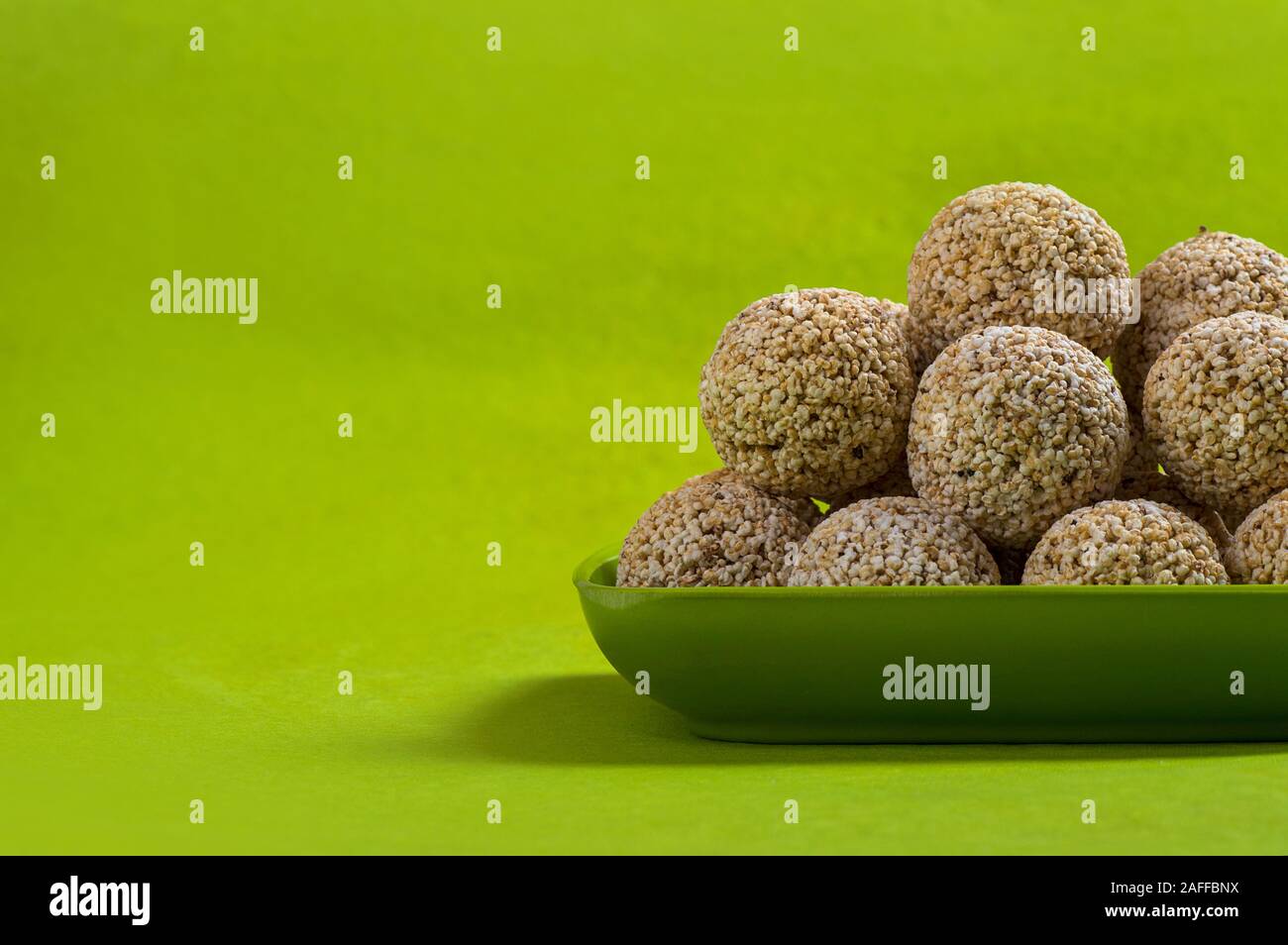 Amaranth oder Rajgira laddu, Cholai ke laddo in grüne Platte auf grünem Hintergrund Stockfoto