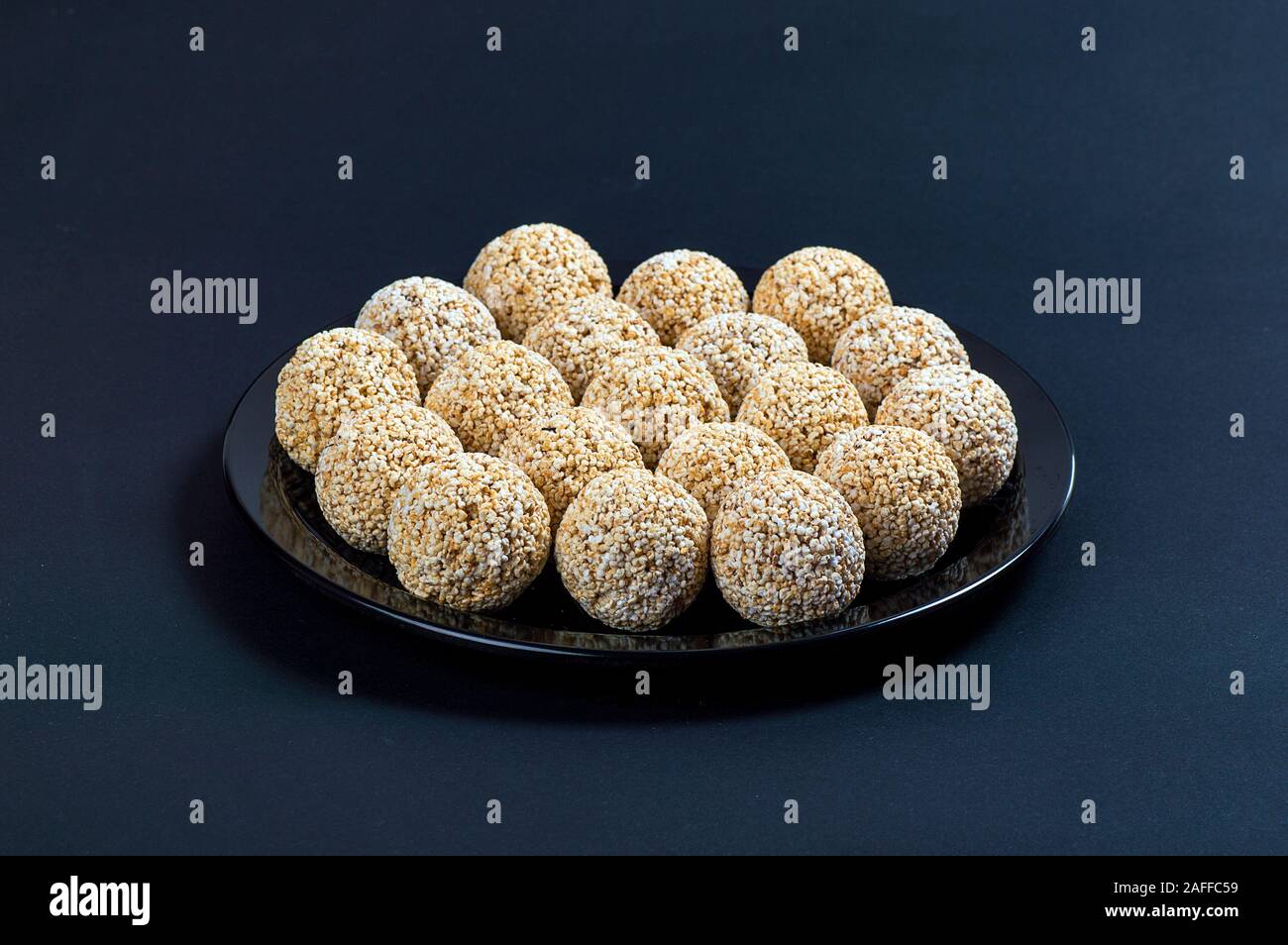 Amaranth ladoo oder Rajgira laddu oder Cholai ke laddo in Schwarz auf schwarzem Hintergrund. Stockfoto