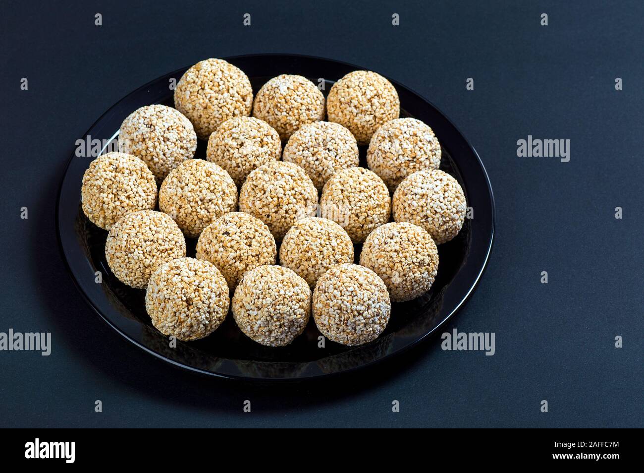 Amaranth ladoo oder Rajgira laddu oder Cholai ke laddo in Schwarz auf schwarzem Hintergrund. Stockfoto