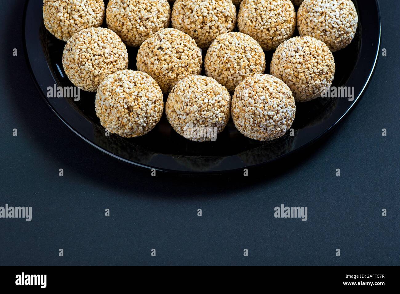 Amaranth ladoo oder Rajgira laddu oder Cholai ke laddo in Schwarz auf schwarzem Hintergrund. Stockfoto