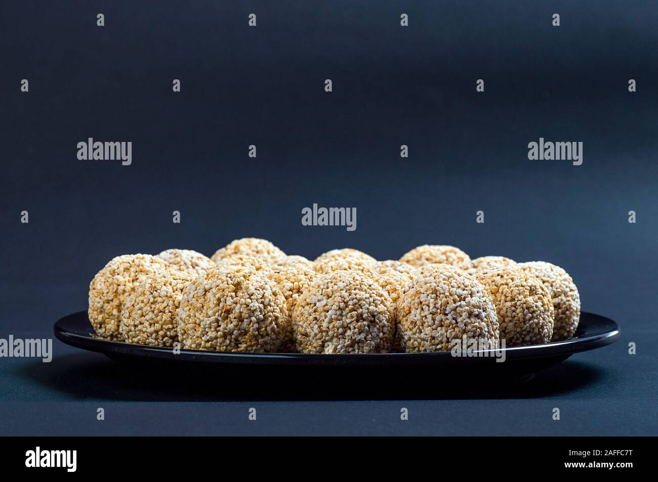 Amaranth ladoo oder Rajgira laddu oder Cholai ke laddo in Schwarz auf schwarzem Hintergrund. Stockfoto