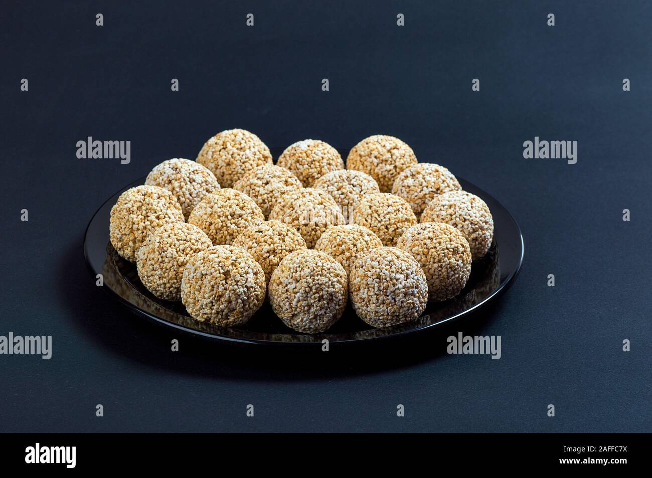 Amaranth ladoo oder Rajgira laddu oder Cholai ke laddo in Schwarz auf schwarzem Hintergrund. Stockfoto