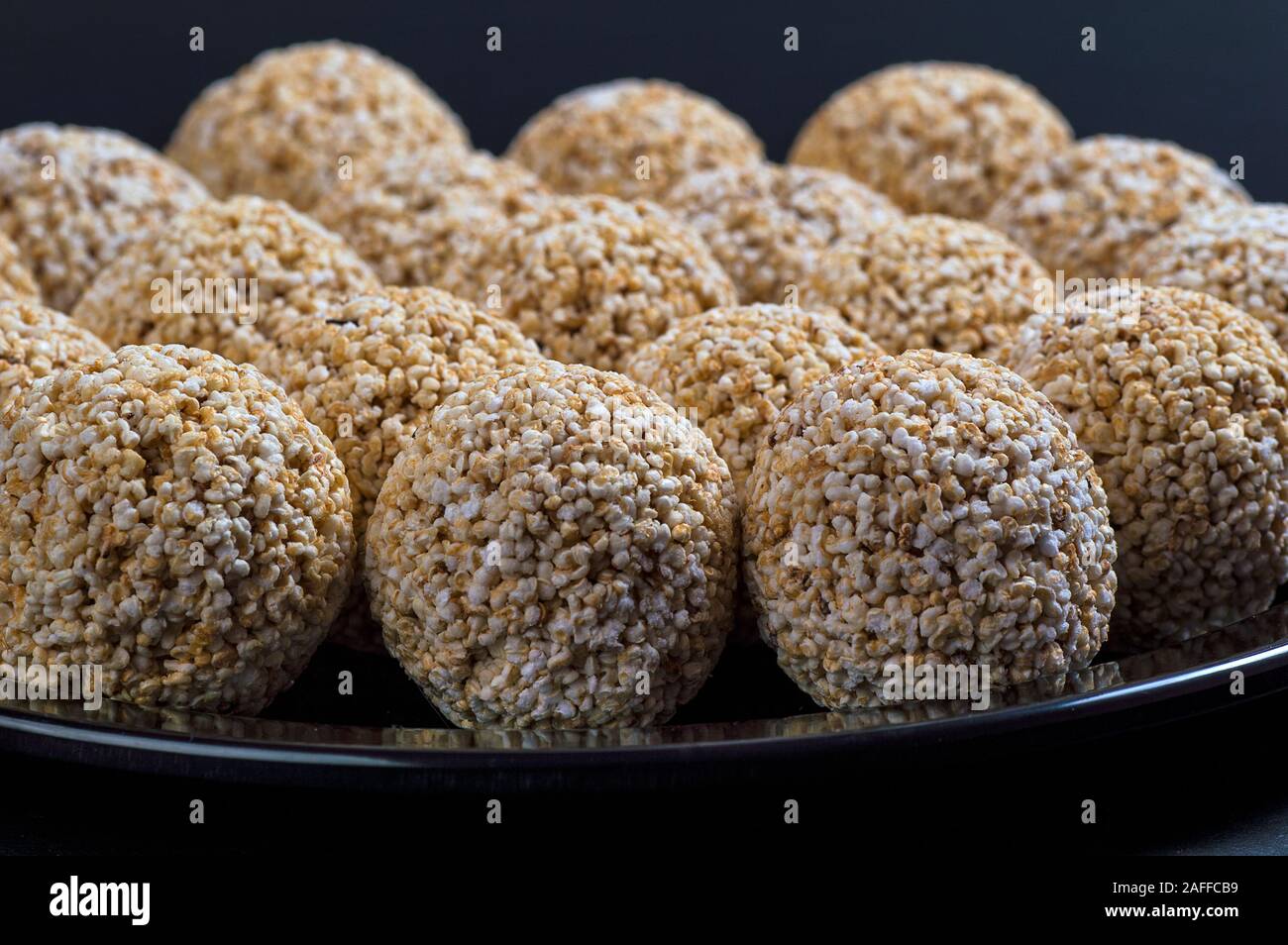 Amaranth ladoo oder Rajgira laddu oder Cholai ke laddo in Schwarz auf schwarzem Hintergrund. Stockfoto
