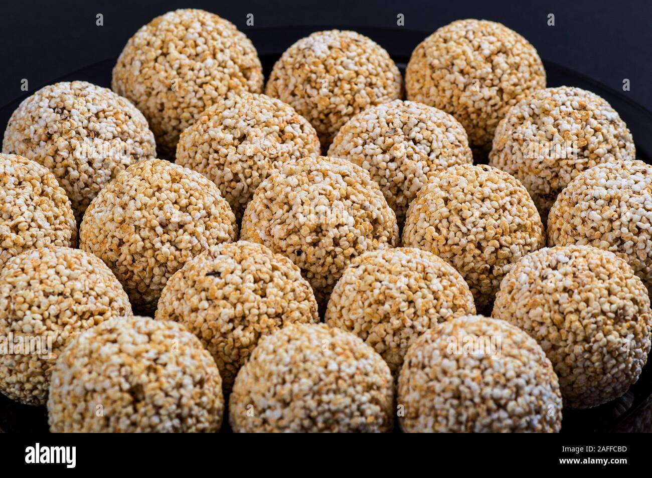 Amaranth ladoo oder Rajgira laddu oder Cholai ke laddo in Schwarz auf schwarzem Hintergrund. Stockfoto