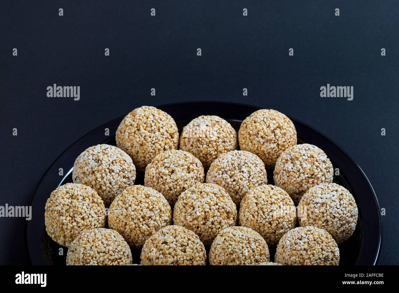 Amaranth ladoo oder Rajgira laddu oder Cholai ke laddo in Schwarz auf schwarzem Hintergrund. Stockfoto