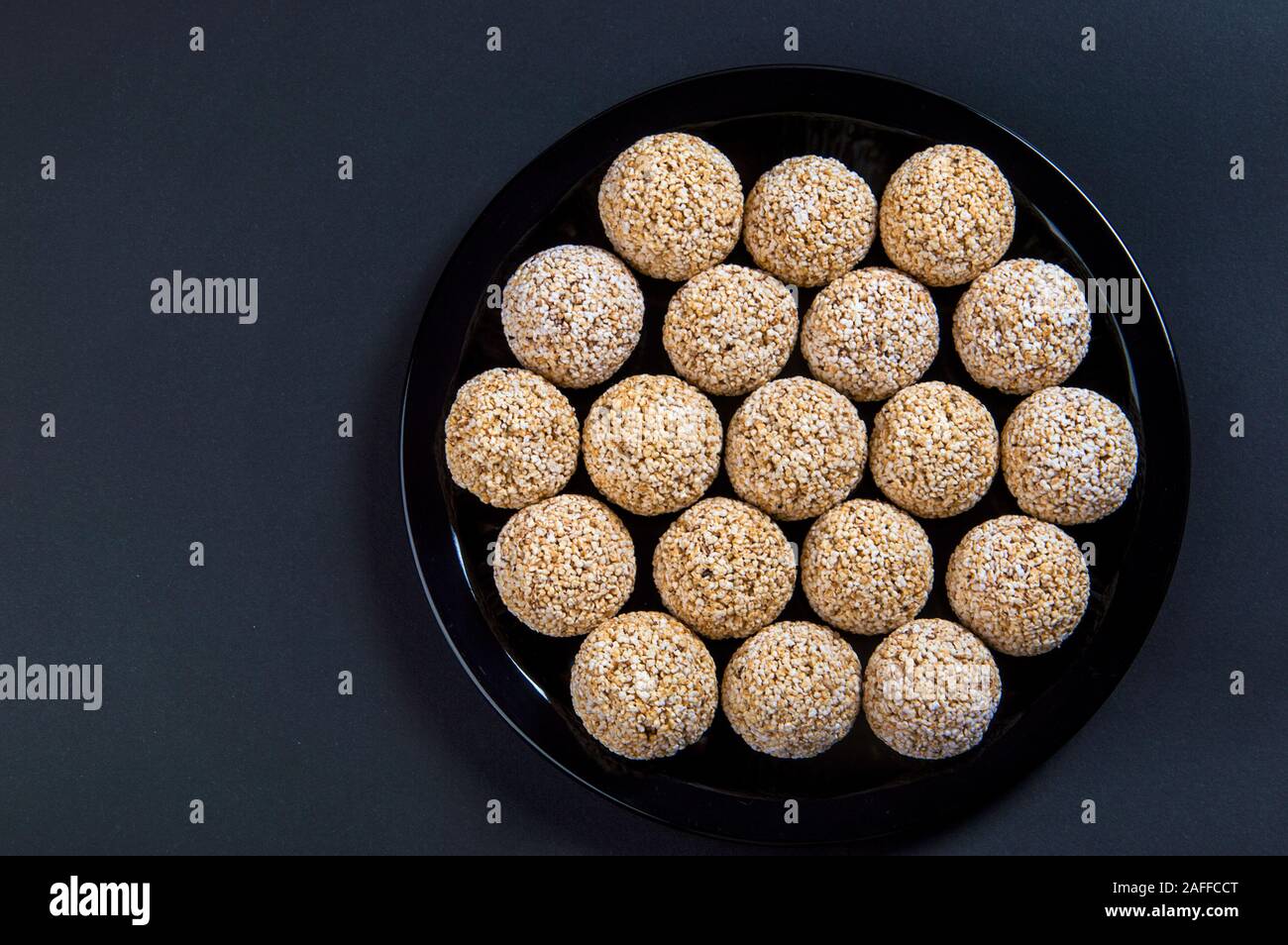 Amaranth ladoo oder Rajgira laddu oder Cholai ke laddo in Schwarz auf schwarzem Hintergrund. Stockfoto