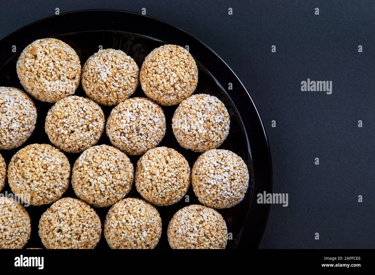 Amaranth ladoo oder Rajgira laddu oder Cholai ke laddo in Schwarz auf schwarzem Hintergrund. Stockfoto