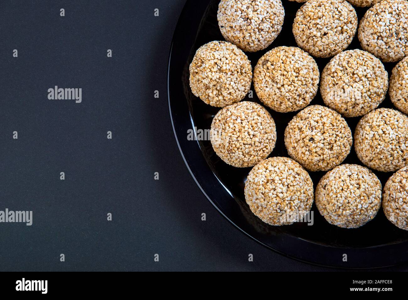 Amaranth ladoo oder Rajgira laddu oder Cholai ke laddo in Schwarz auf schwarzem Hintergrund. Stockfoto