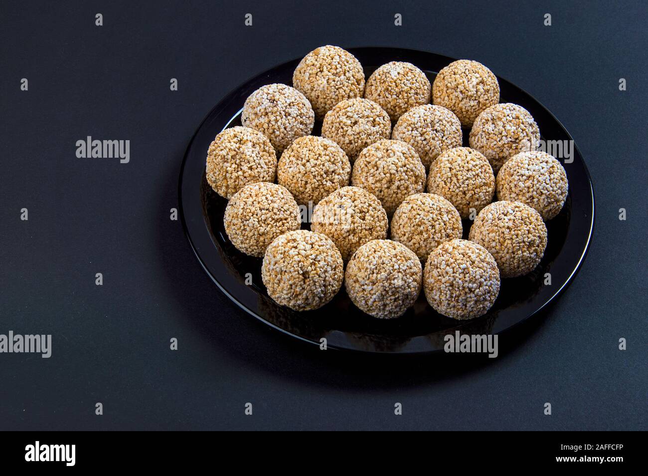 Amaranth ladoo oder Rajgira laddu oder Cholai ke laddo in Schwarz auf schwarzem Hintergrund. Stockfoto
