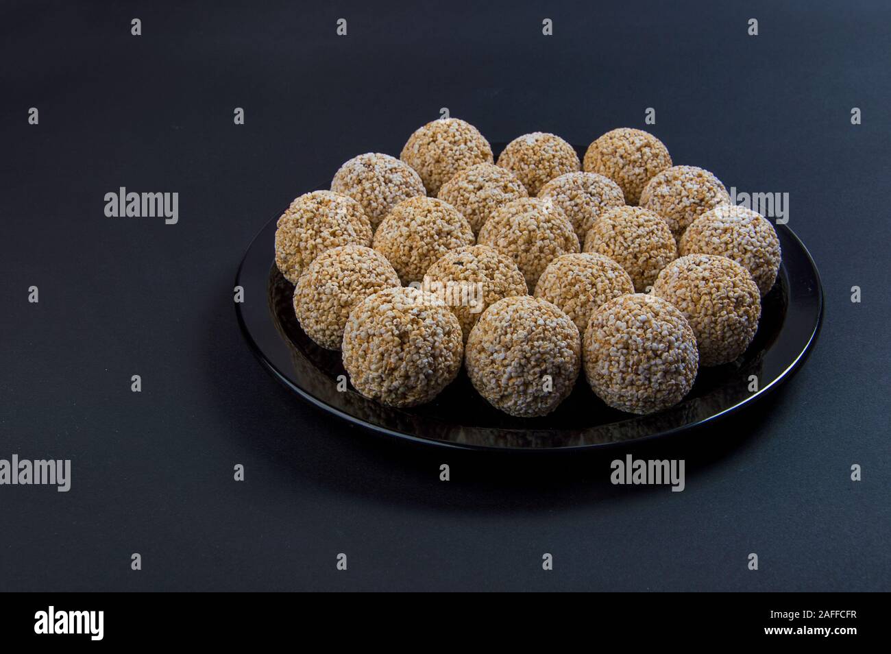 Amaranth ladoo oder Rajgira laddu oder Cholai ke laddo in Schwarz auf schwarzem Hintergrund. Stockfoto
