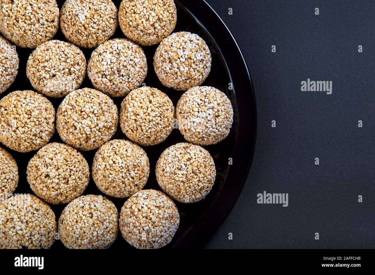Amaranth ladoo oder Rajgira laddu oder Cholai ke laddo in Schwarz auf schwarzem Hintergrund. Stockfoto