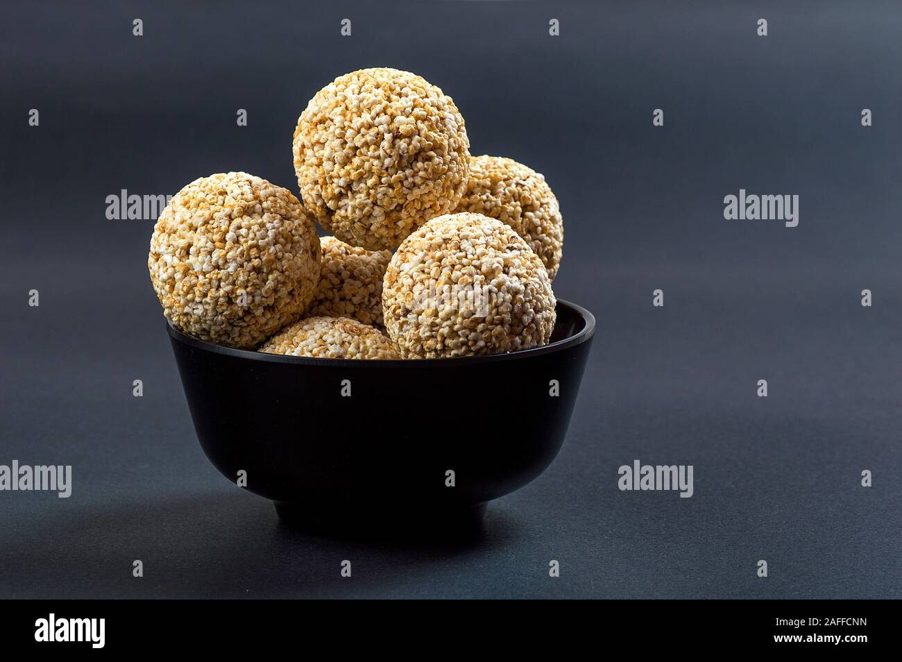 Amaranth oder Rajgira laddu, Cholai ke laddo in schwarz Schüssel auf schwarzem Hintergrund Stockfoto