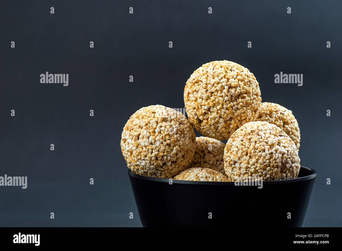 Amaranth oder Rajgira laddu, Cholai ke laddo in schwarz Schüssel auf schwarzem Hintergrund Stockfoto