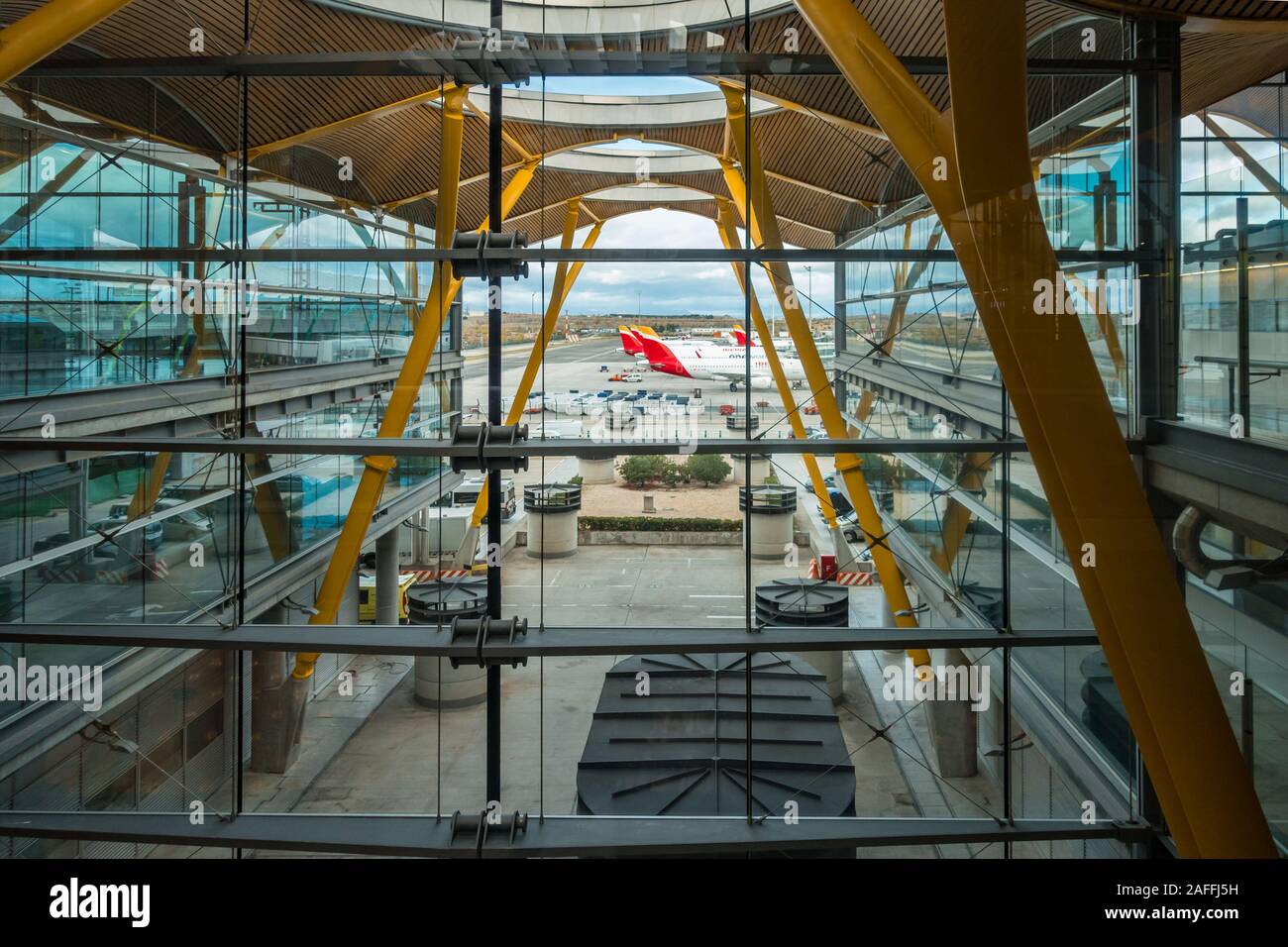 Auf der Suche durch moderne Glasfenster im Terminal 4 des Flughafens Madrid-Barajas Adolfo Suárez Flughafen in Madrid, Spanien bei Flugzeugen saß auf der Landebahn. Stockfoto