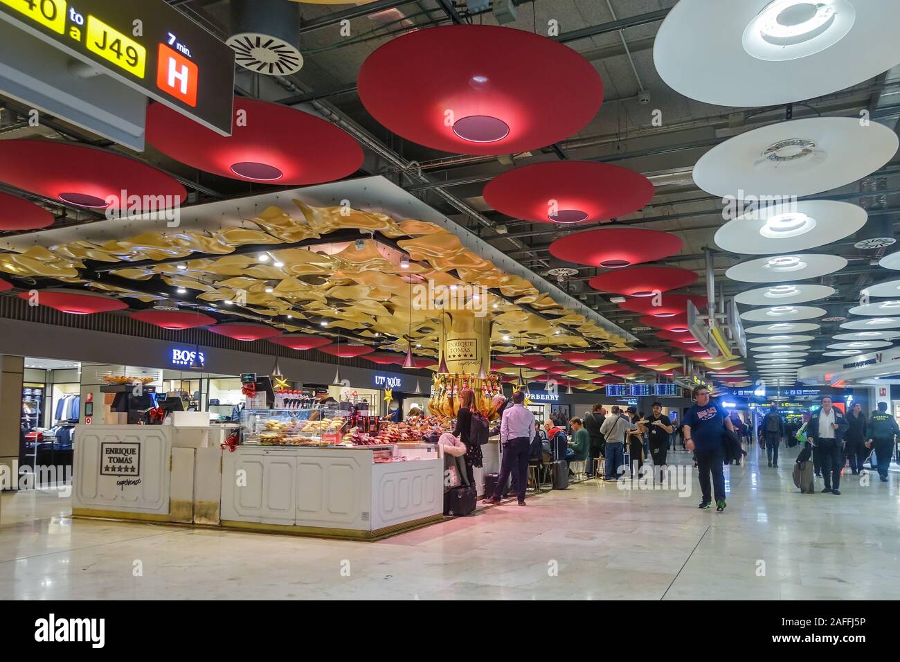 Ein Restaurant im Terminal 4 des Flughafens Madrid-Barajas Adolfo Suárez Abflüge am Flughafen in Madrid, Spanien. Die Decke verfügt über große, runde, Feuerzeuge. Stockfoto