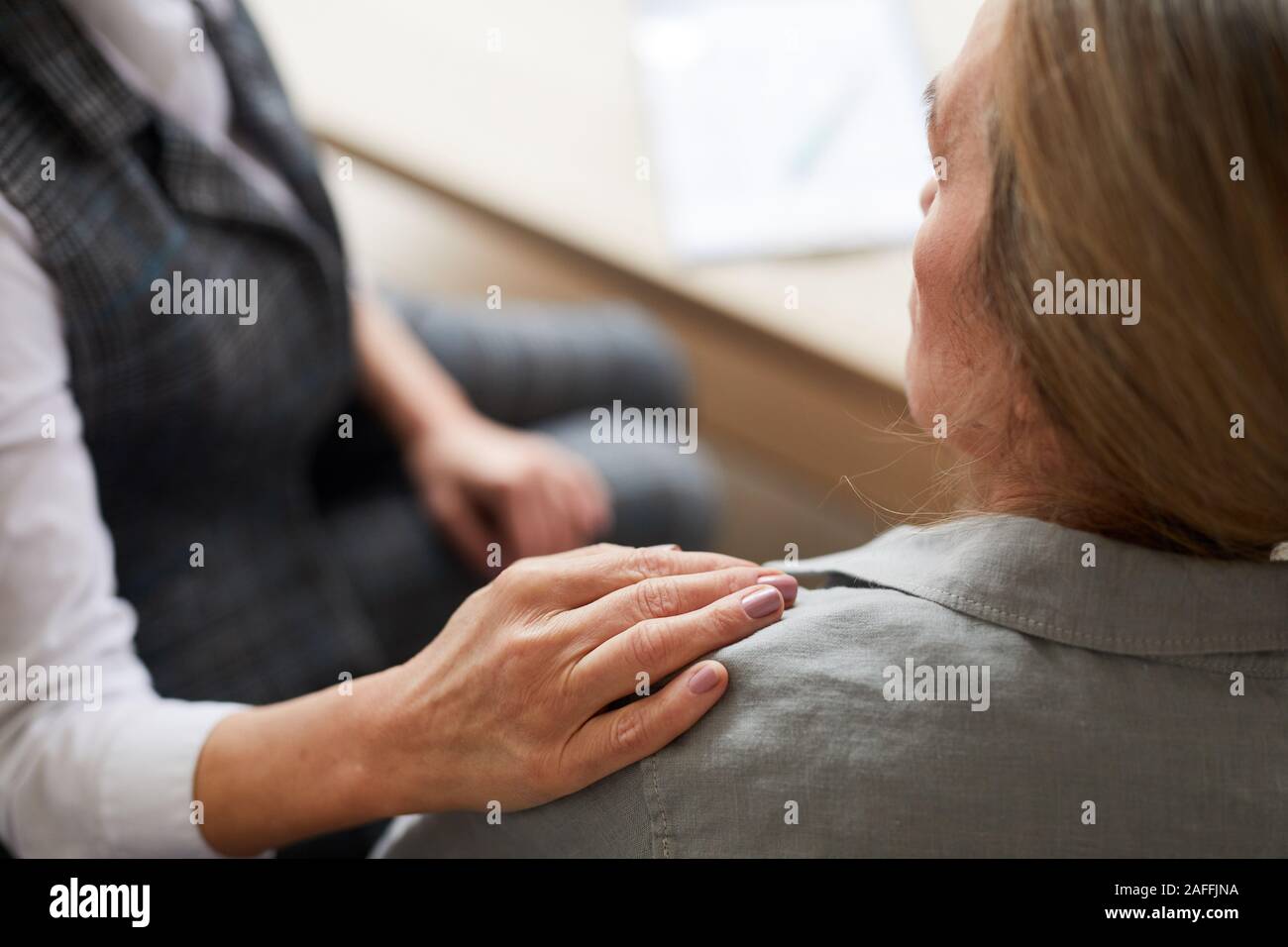 Nahaufnahme der Psychologin über die Hand auf die Schulter des älteren Patienten, während ihr beruhigend während der therapiesitzung, kopieren Raum Stockfoto