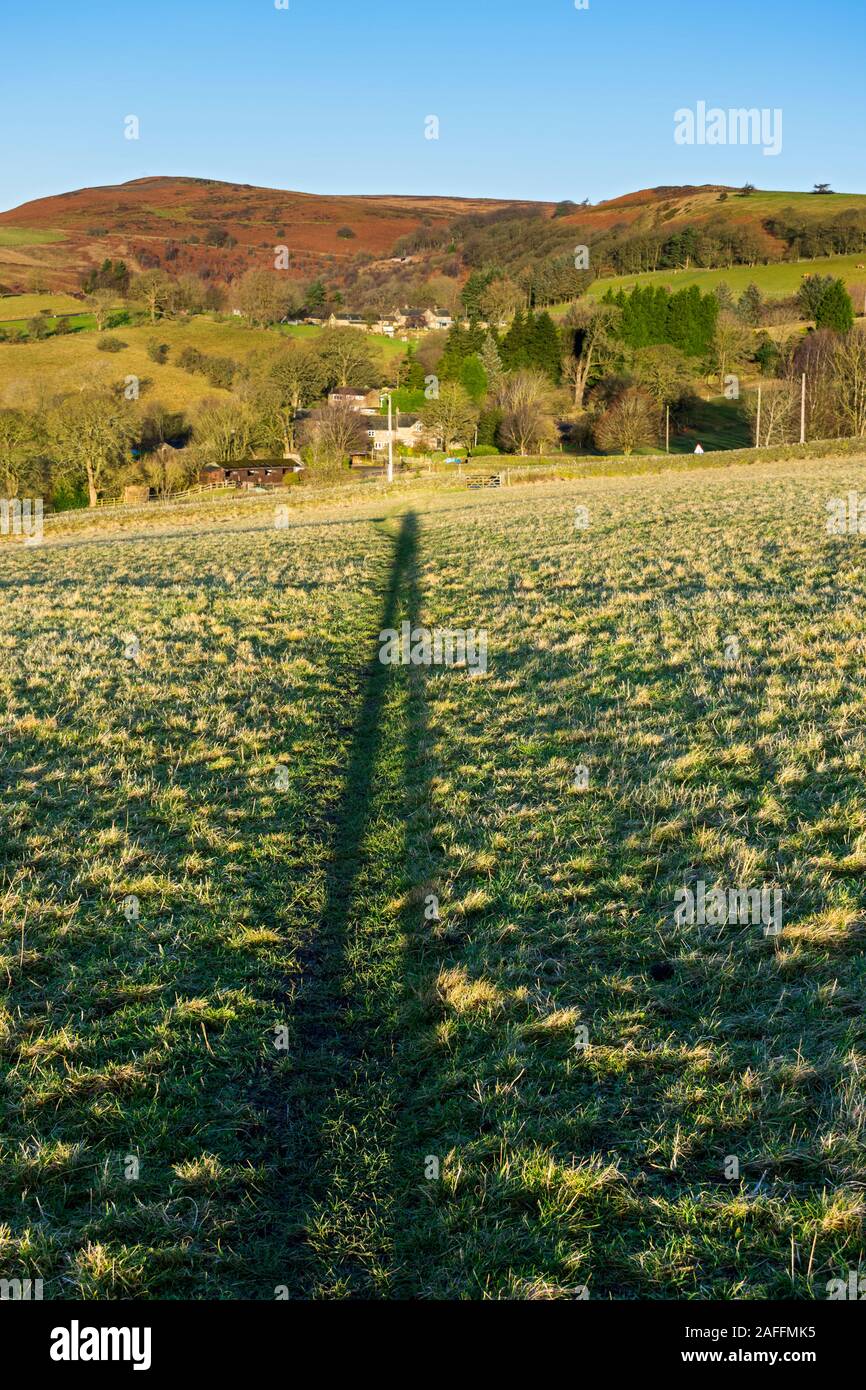 Die Sonne Schatten des Fotografen direkt entlang der Linie der Weg über ein Feld, in der Nähe von Hathersage, Peak District, Derbyshire, England, UK. Stockfoto